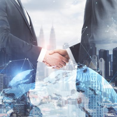 Businessmen shaking hands on bright white city background with globe and polygonal connections. Teamwork and success concept. Double exposure